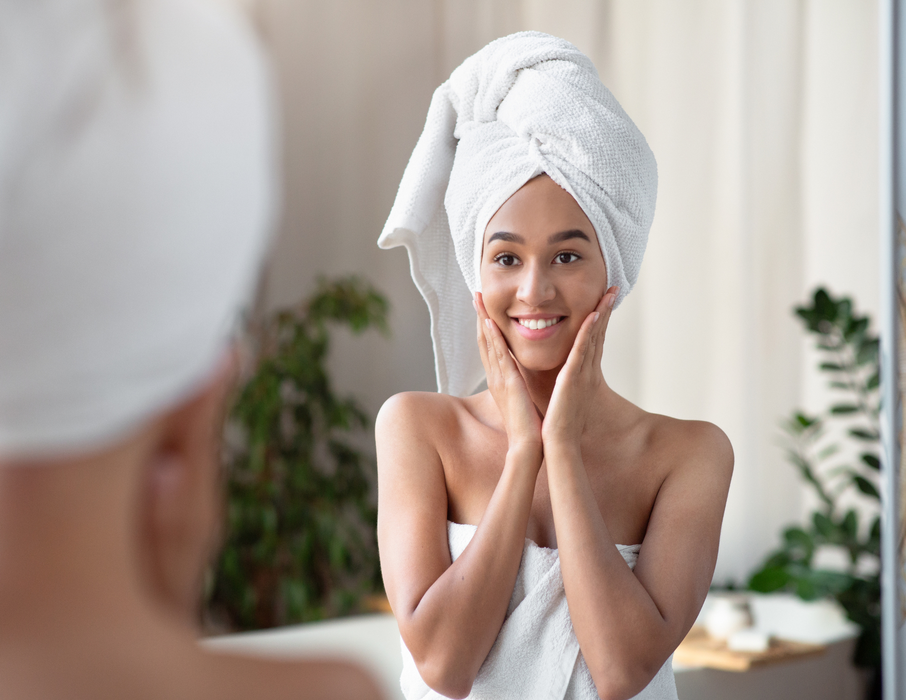 Women of color looking in the mirror after taking a bath