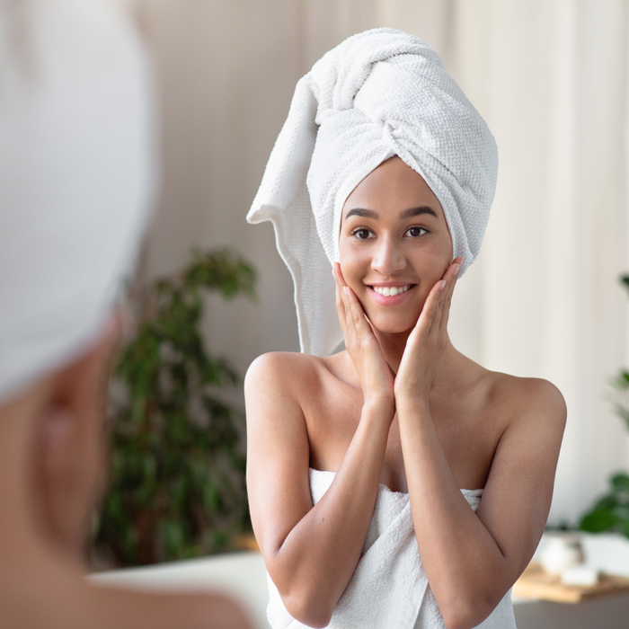 Women of color looking in the mirror after taking a bath